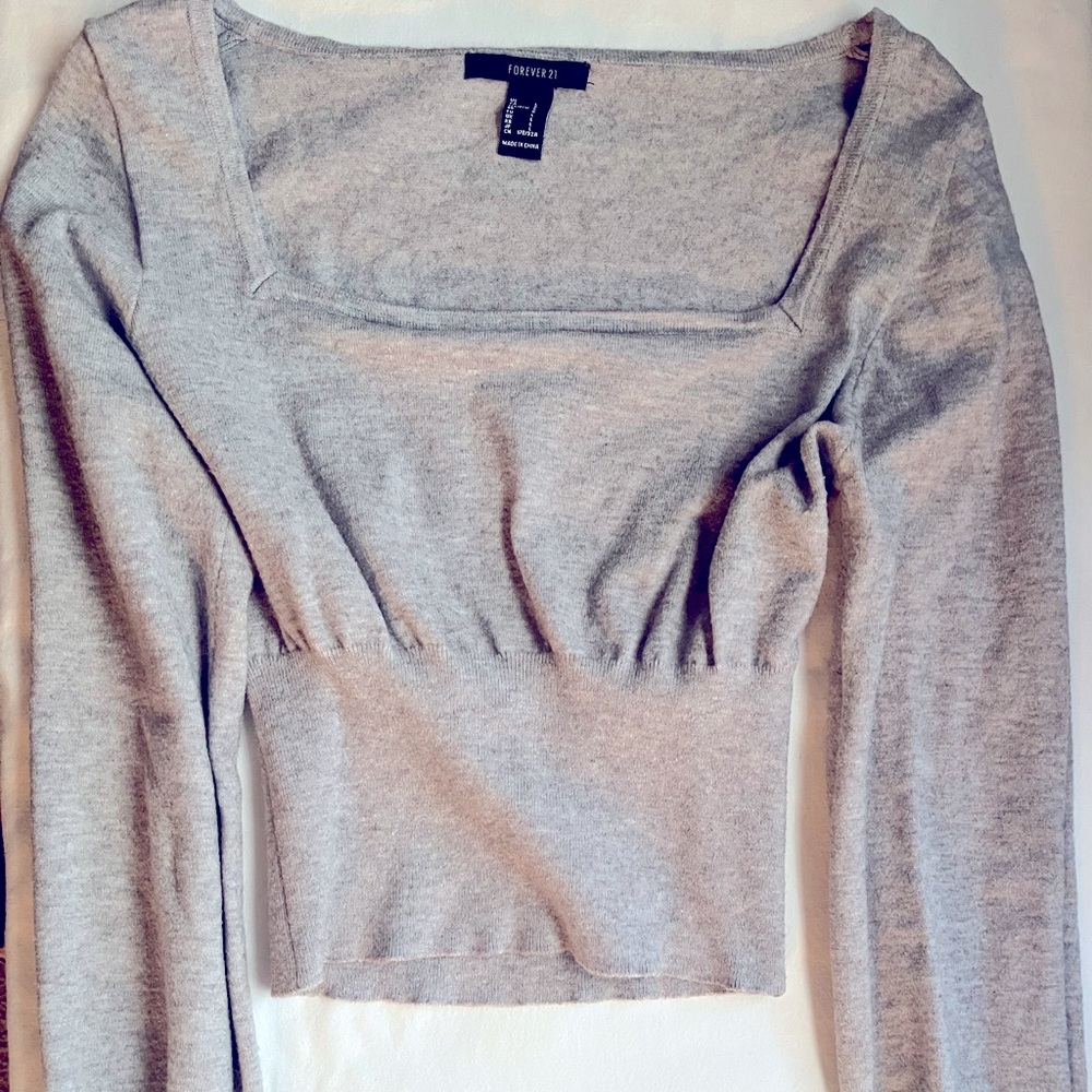 Sweater, square neckline . Long sleeve and Grey in color. Medium in size .